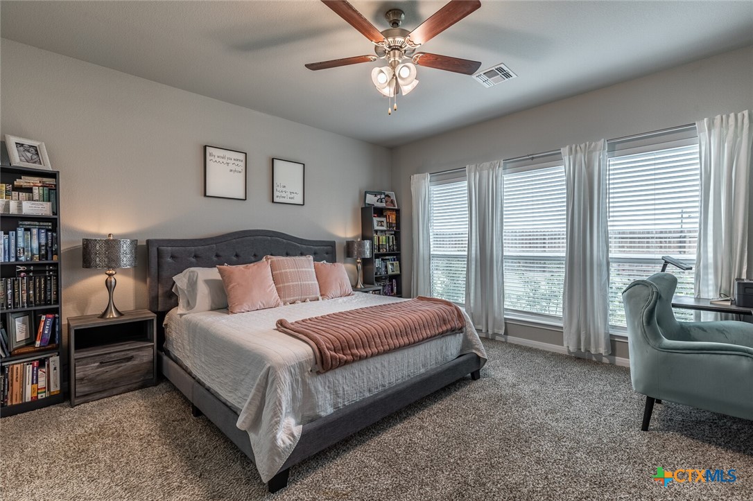 6142 Fairburn Temple, TX 76502 - Photo 17 of 38 a spacious bedroom with a bed a couch and large windows