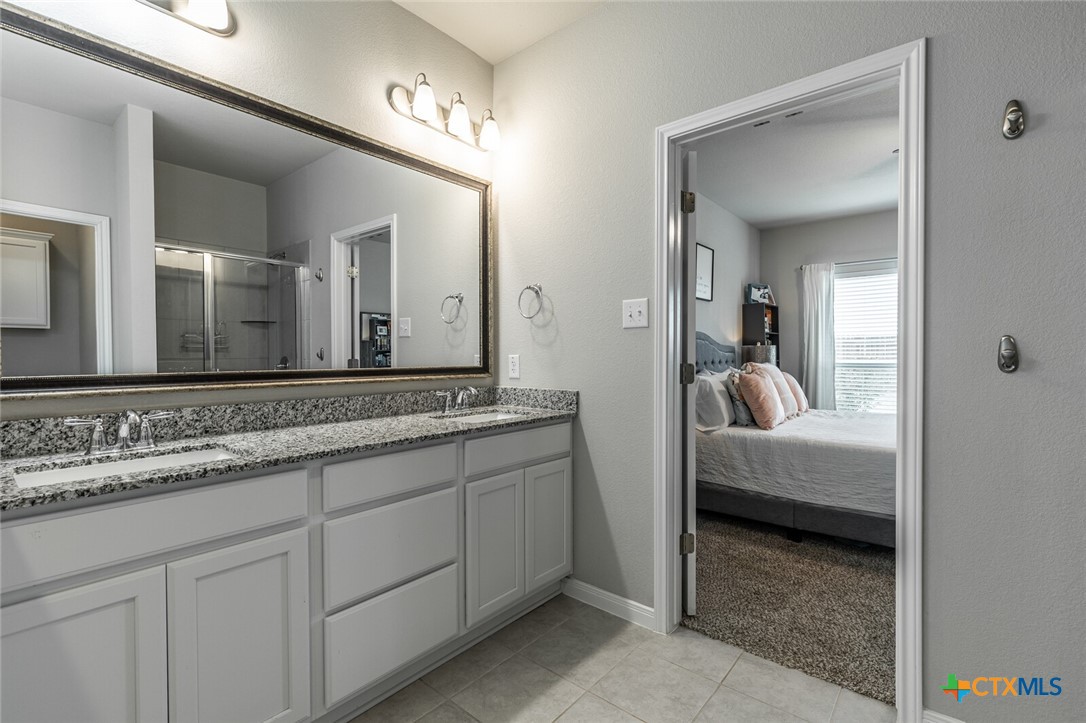 6142 Fairburn Temple, TX 76502 - Photo 21 of 38 a en suite bathroom with a granite countertop sink and a mirror