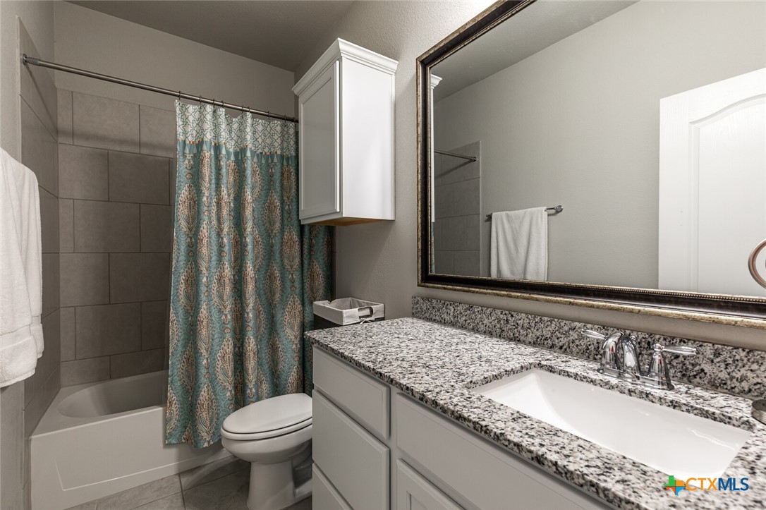 6142 Fairburn Temple, TX 76502 - Photo 27 of 38 a bathroom with a granite countertop sink toilet and shower