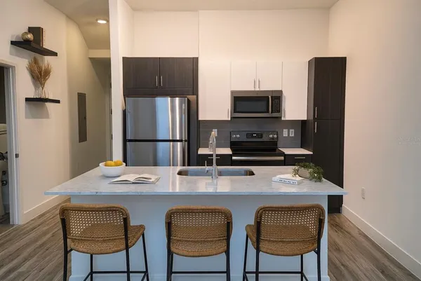 a kitchen with stainless steel appliances a stove refrigerator and microwave