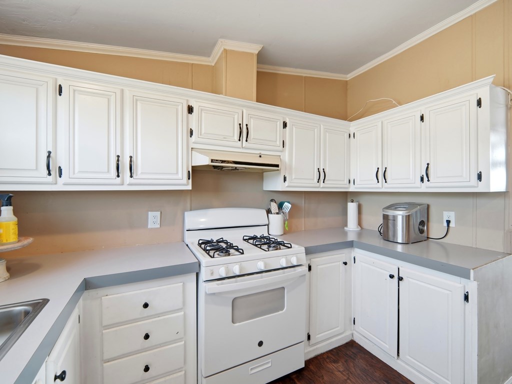 127 Windmill Drive Bandera, TX 78003 - Photo 11 of 29 a kitchen with granite countertop white cabinets and white appliances