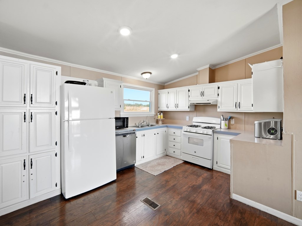 127 Windmill Drive Bandera, TX 78003 - Photo 12 of 29 a kitchen with white cabinets and white appliances