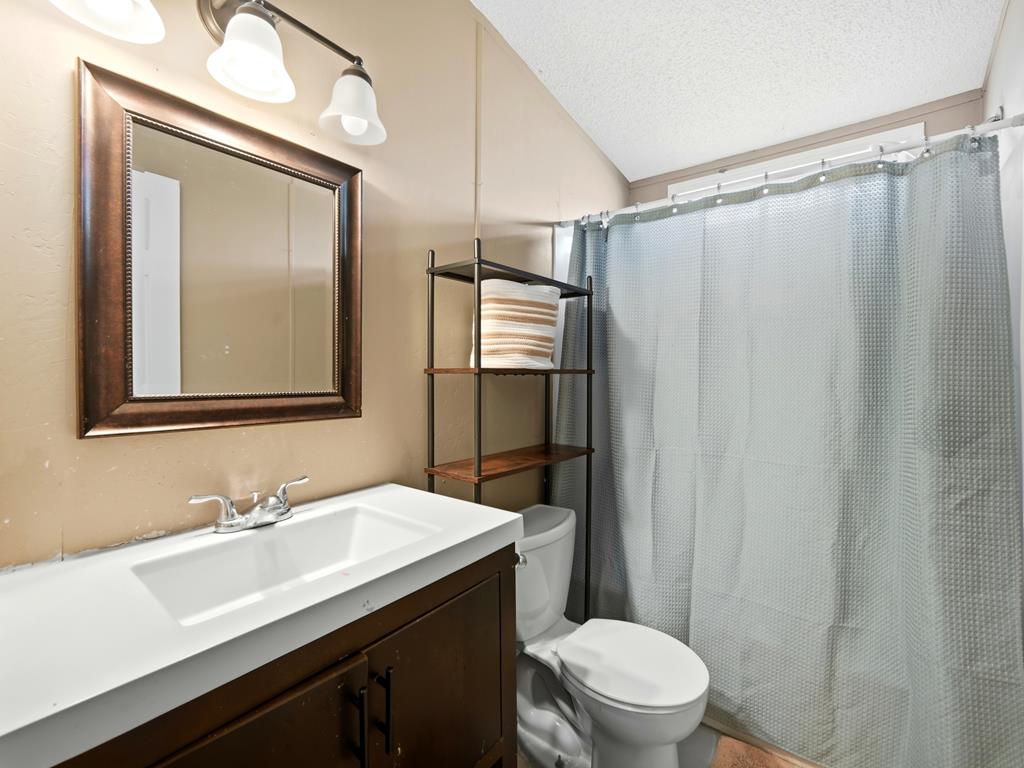 127 Windmill Drive Bandera, TX 78003 - Photo 15 of 29 a bathroom with a sink a toilet a mirror and shower