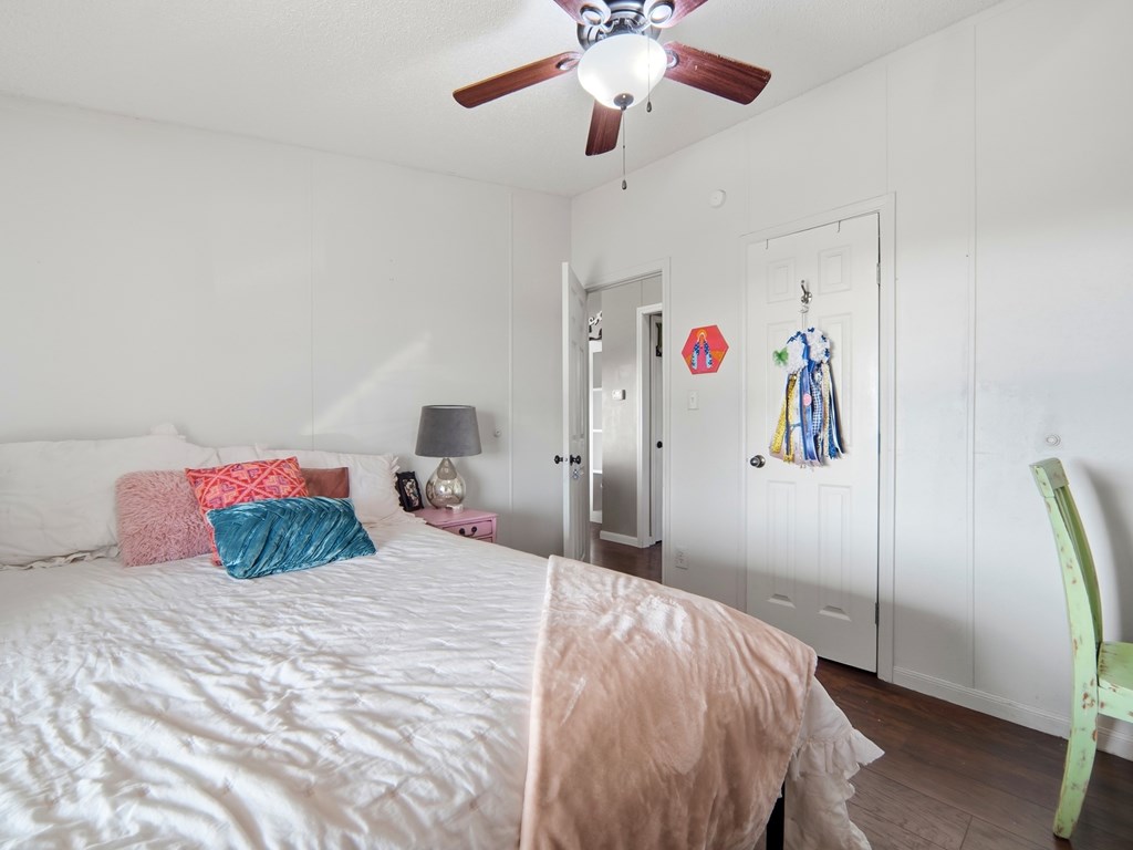 127 Windmill Drive Bandera, TX 78003 - Photo 17 of 29 a bedroom with a large bed and a chandelier