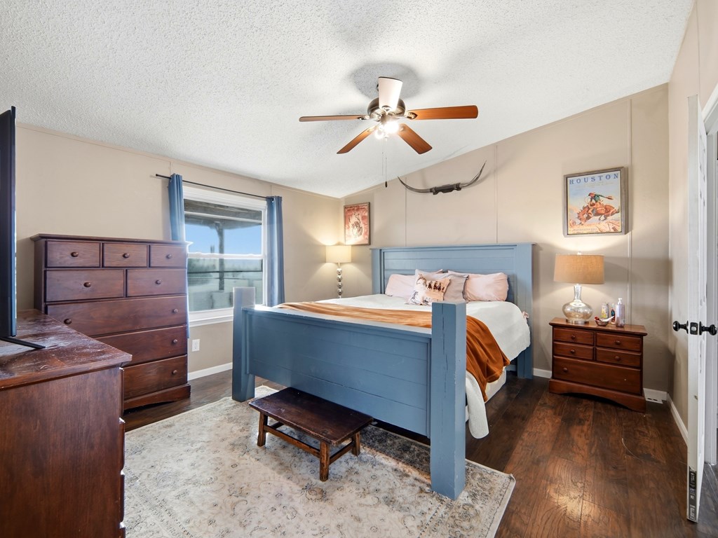 127 Windmill Drive Bandera, TX 78003 - Photo 20 of 29 a bedroom with a bed and a chandelier