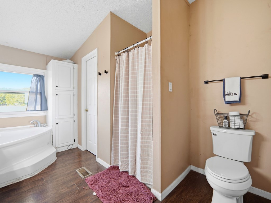 127 Windmill Drive Bandera, TX 78003 - Photo 23 of 29 a bathroom with a granite countertop toilet a sink and a bathtub