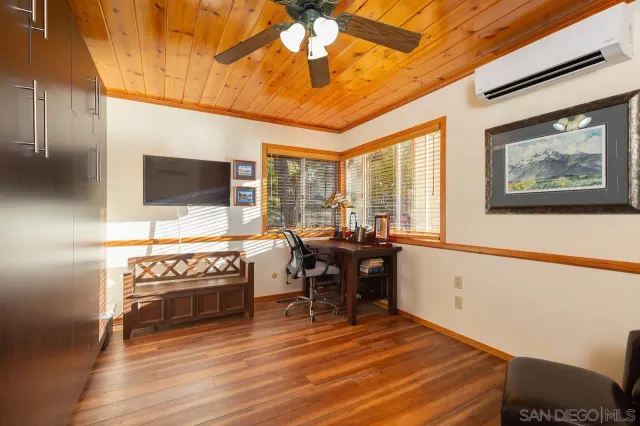 a living room with furniture a flat screen tv and floor to ceiling window
