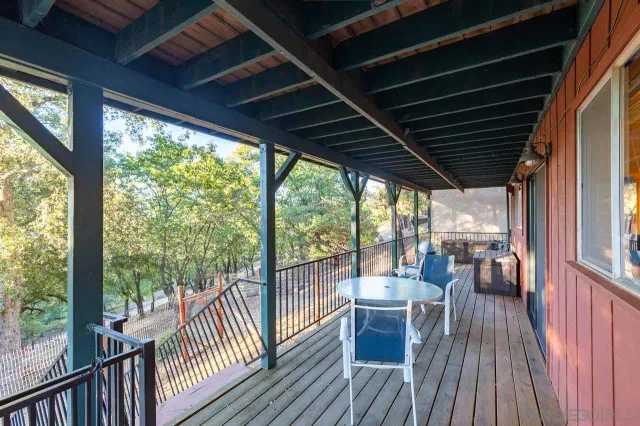 a view of a house with large tree and wooden fence