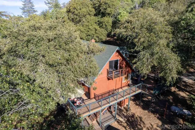 a backyard of a house with wooden floor and fence and a bench