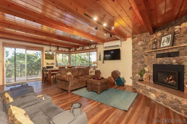 a dining room with furniture large windows and wooden floor