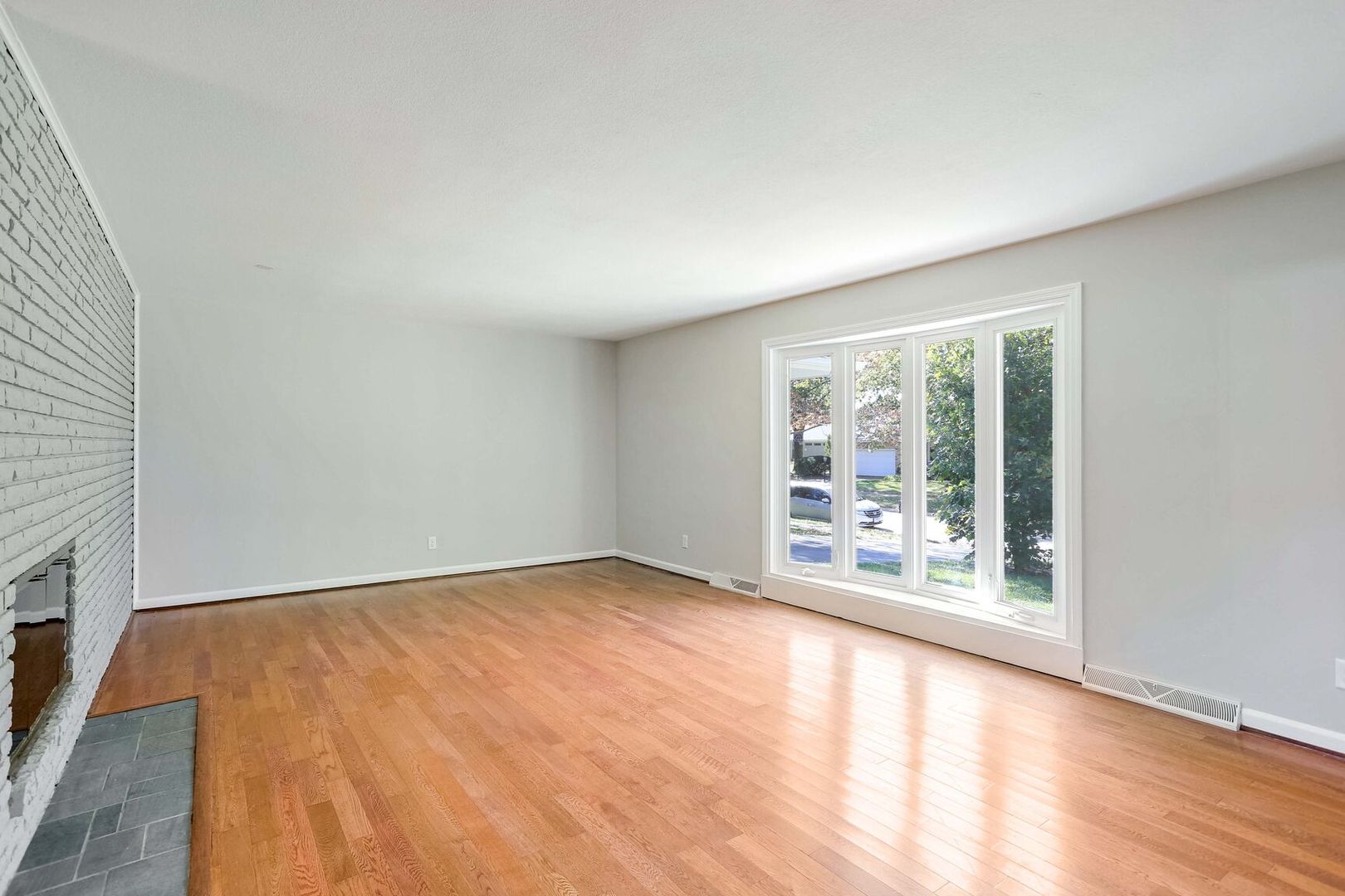 1716 Georgetown Drive Champaign, IL 61821 - Photo 8 of 36 a view of an empty room with a window and wooden floor