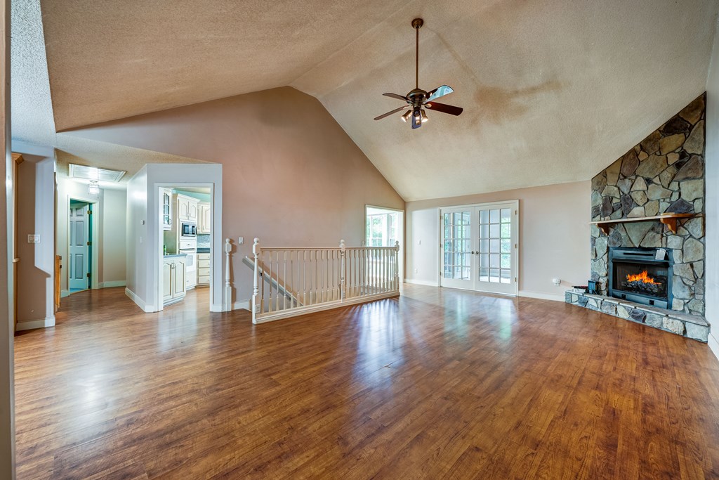 9327 Highway 52 Chatsworth, GA 30705 - Photo 5 of 43 a view of an empty room with wooden floor fireplace and a window