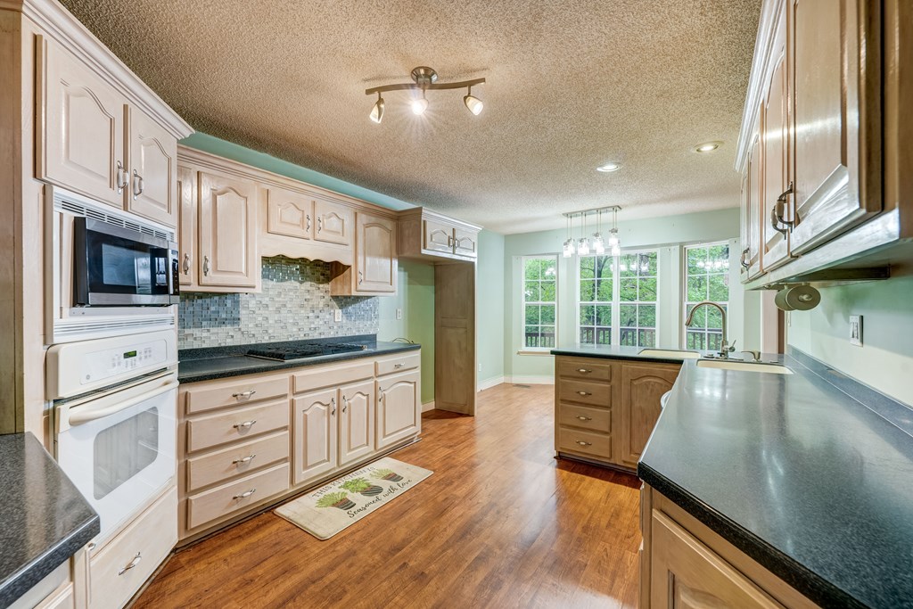 9327 Highway 52 Chatsworth, GA 30705 - Photo 6 of 43 a kitchen with stainless steel appliances granite countertop a stove a sink and a refrigerator