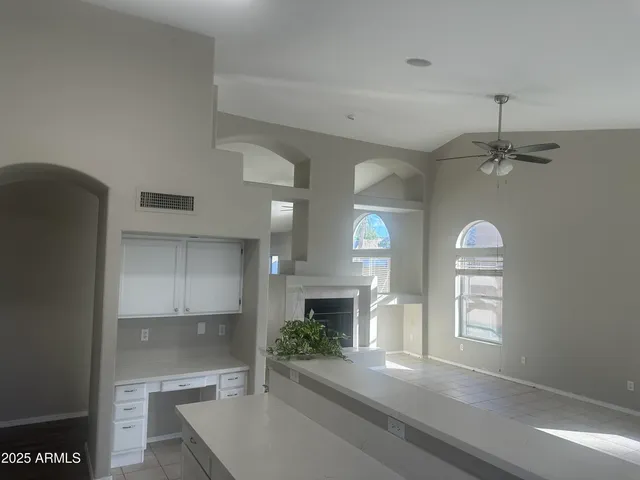 a large white kitchen with a sink a refrigerator and cabinets