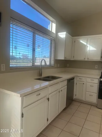 a kitchen with white cabinets and sink