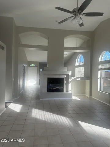 view of an empty room with a fireplace and a window