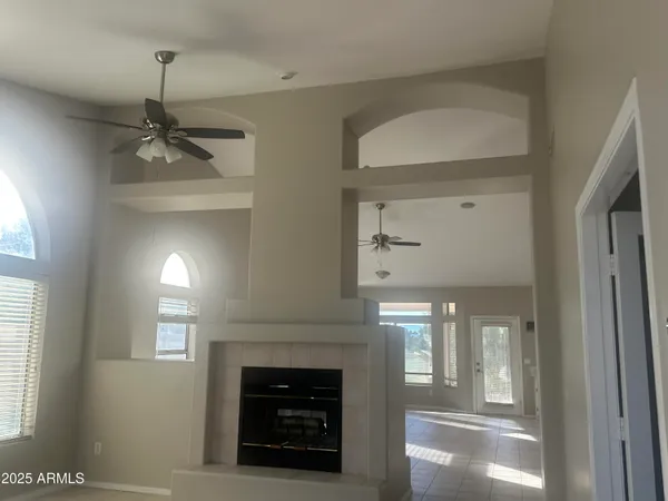 a view of a livingroom with a fireplace a chandelier and stairs