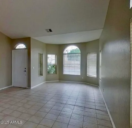 view of an empty room with a fireplace and a window