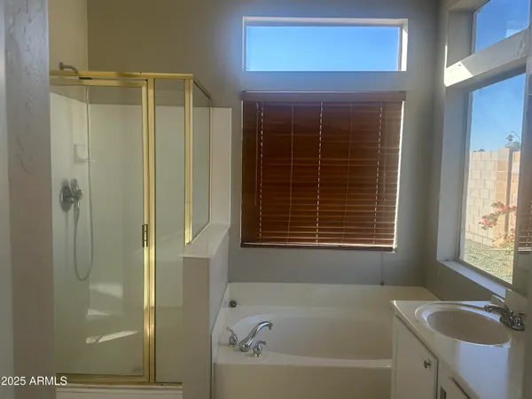 a bathroom with a shower a window and a sink