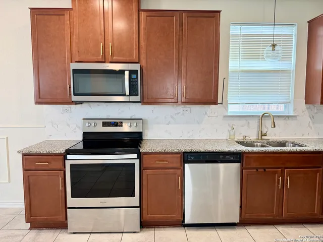 a kitchen with stainless steel appliances granite countertop a refrigerator and a sink