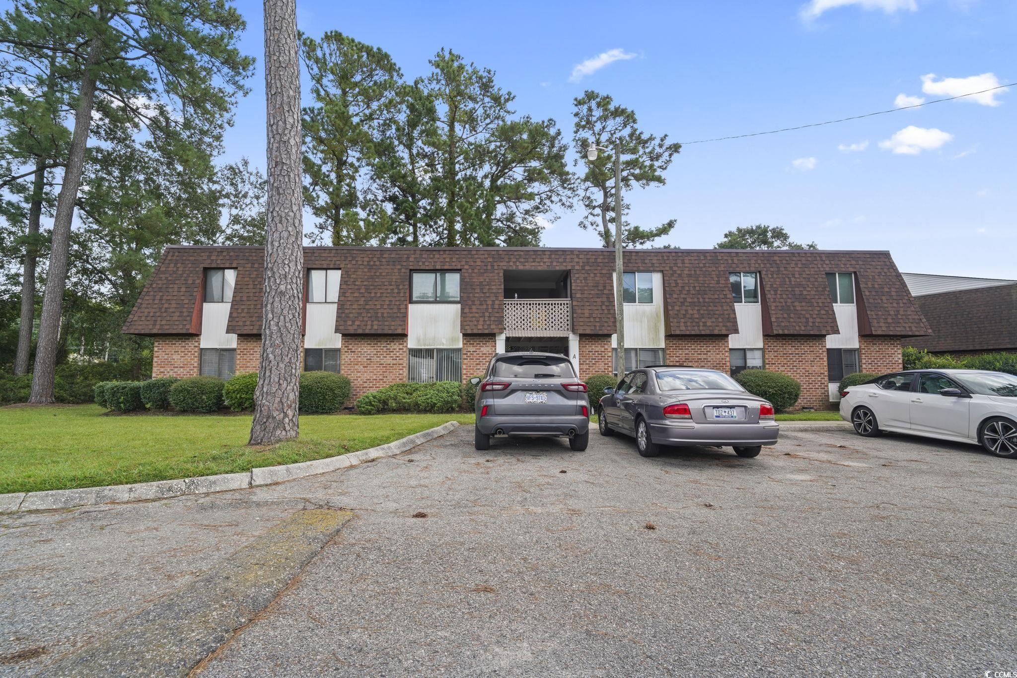 View of building exterior with uncovered parking