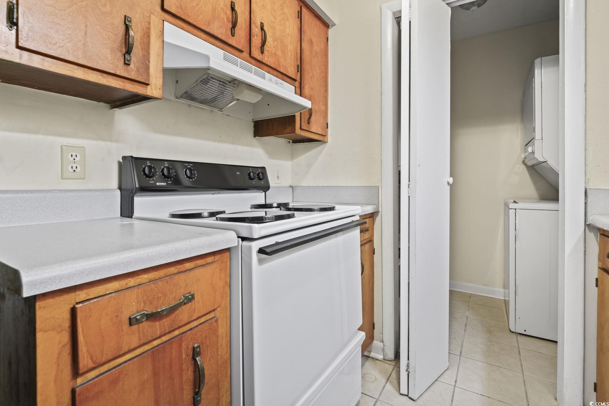 615 Carter Lane, Unit A1 Conway, SC 29526 - Photo 17 of 31 Kitchen with white electric range oven, brown cabinetry, light countertops, light tile patterned floors, and under cabinet range hood