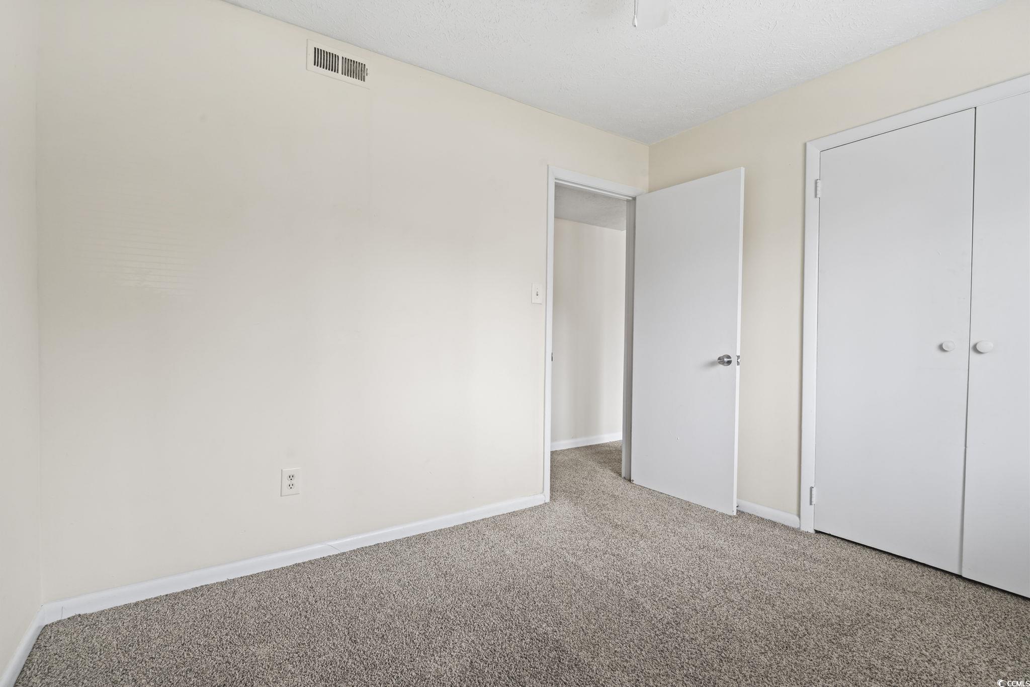 615 Carter Lane, Unit A1 Conway, SC 29526 - Photo 21 of 31 Unfurnished bedroom with carpet floors, a closet, and a textured ceiling