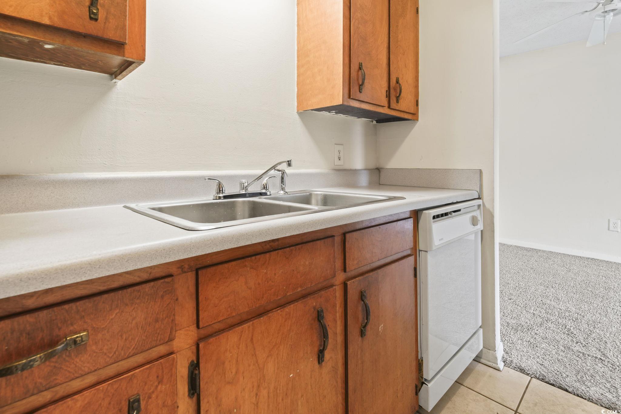 615 Carter Lane, Unit A1 Conway, SC 29526 - Photo 28 of 31 Kitchen with dishwasher, brown cabinetry, light carpet, and light countertops