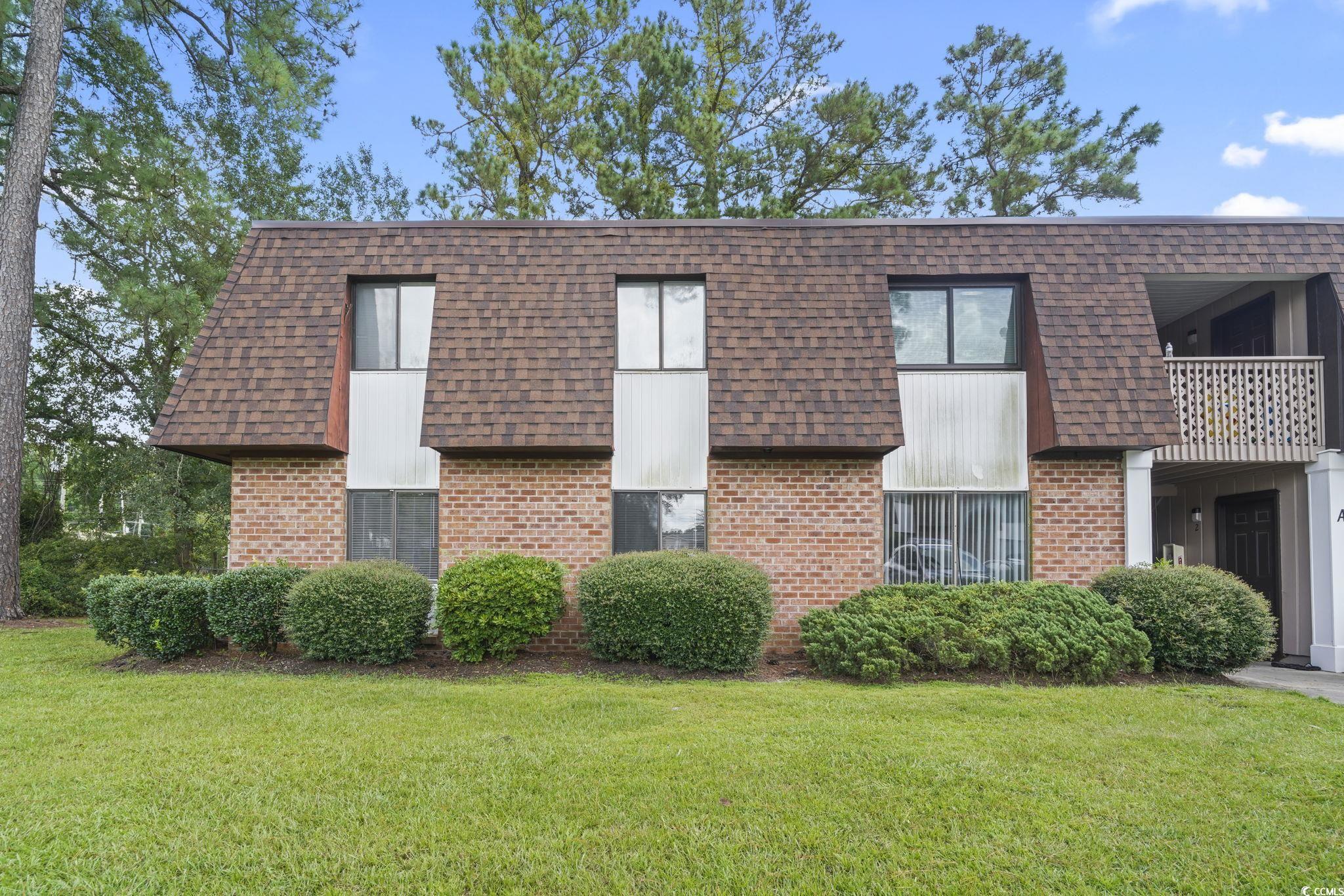 615 Carter Lane, Unit A1 Conway, SC 29526 - Photo 30 of 31 View of front of property with brick siding, mansard roof, a front yard, and roof with shingles