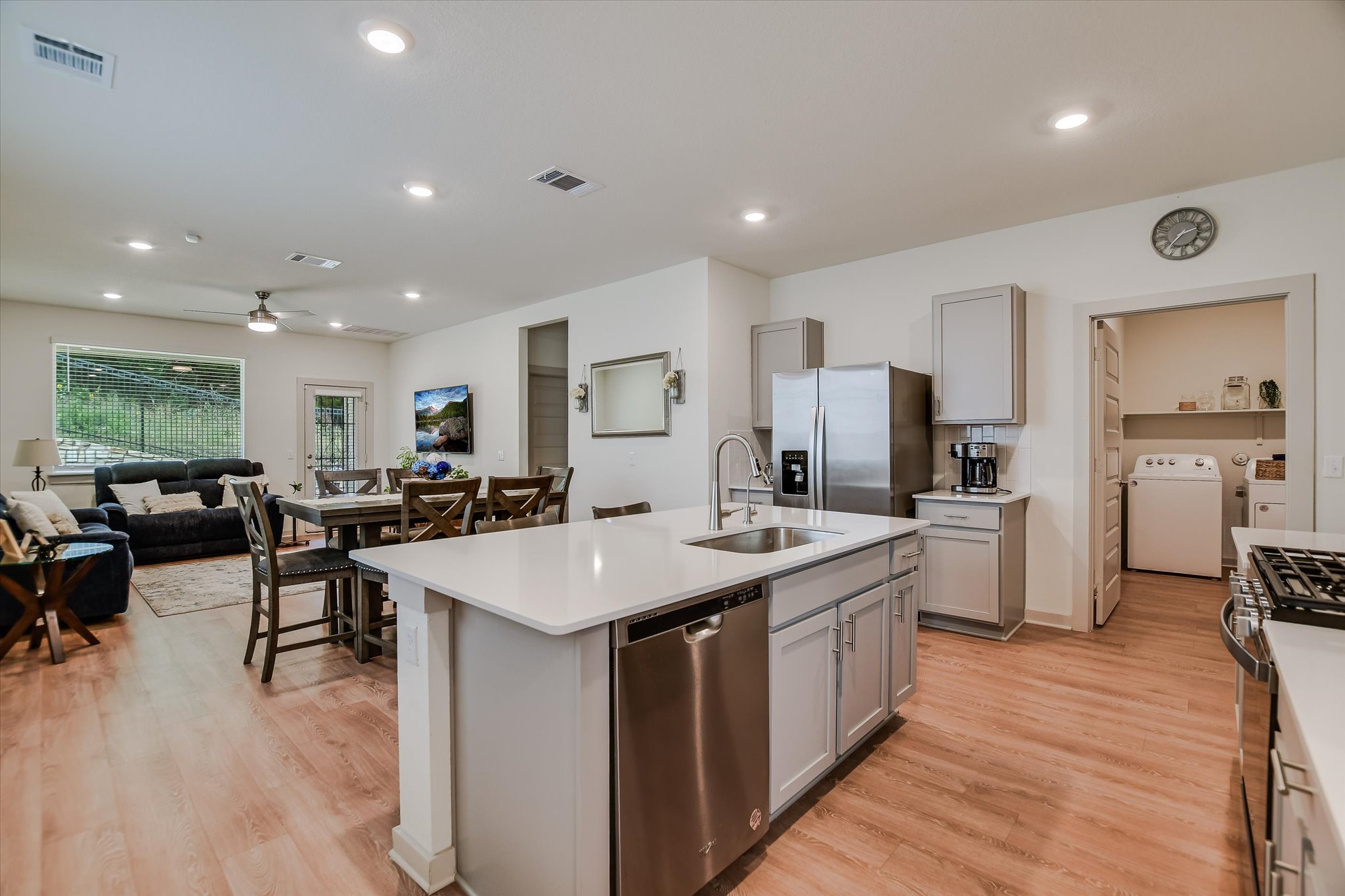 105 Merrick Road Georgetown, TX 78628 - Photo 3 of 23 A contemporary open-concept layout connects the well-appointed kitchen to the dining and living spaces, all featuring durable hardwood-style flooring.
