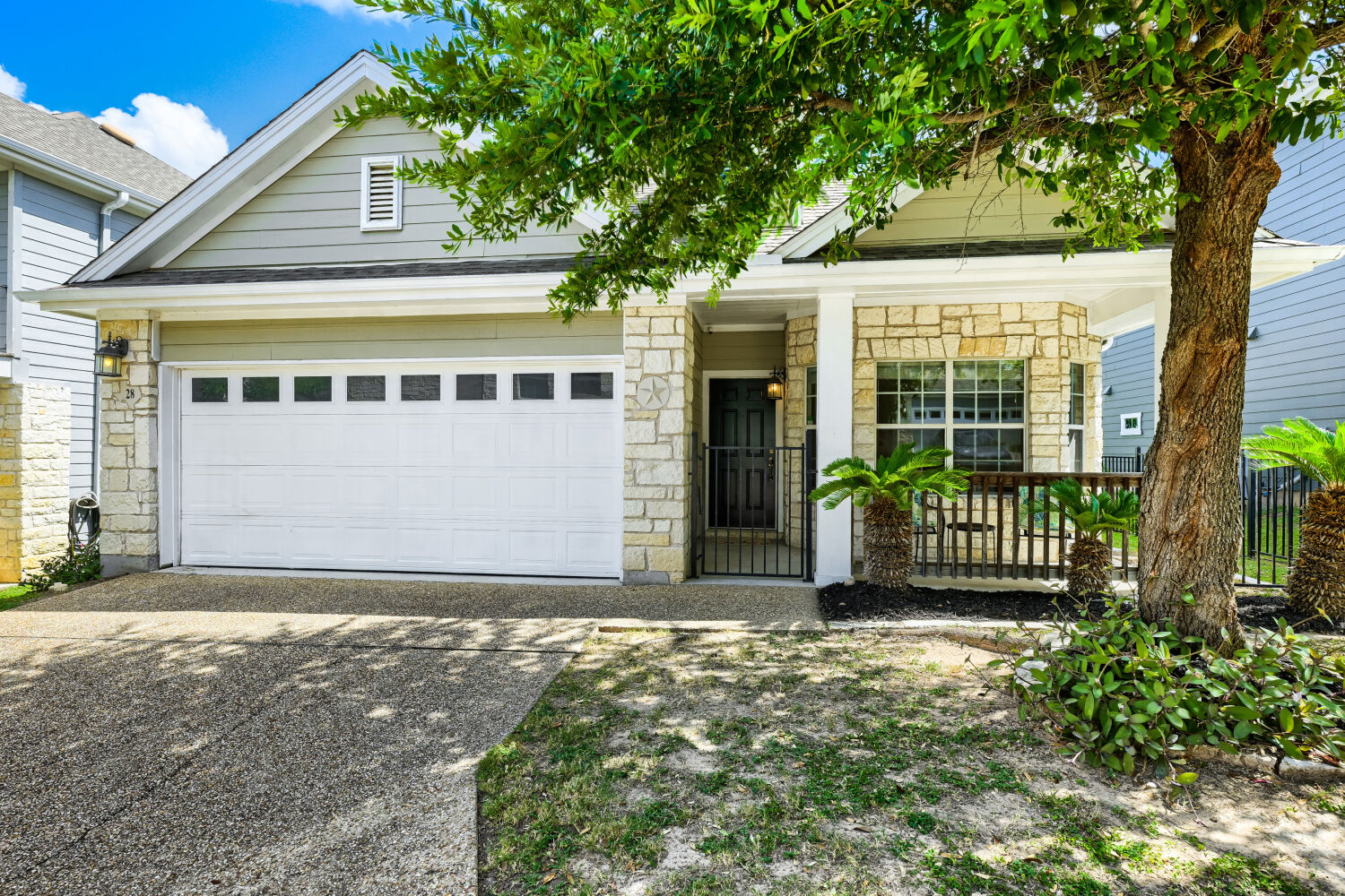 Texas stone single-story home with large front porch and shade!
