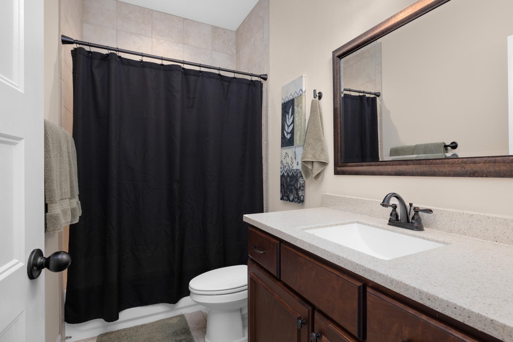 504 Bankston Road Nesbit, MS 38651 - Photo 23 of 39 Bathroom vanity with a white rectangular undermount sink, a dark bronze faucet, and a light speckled countertop
