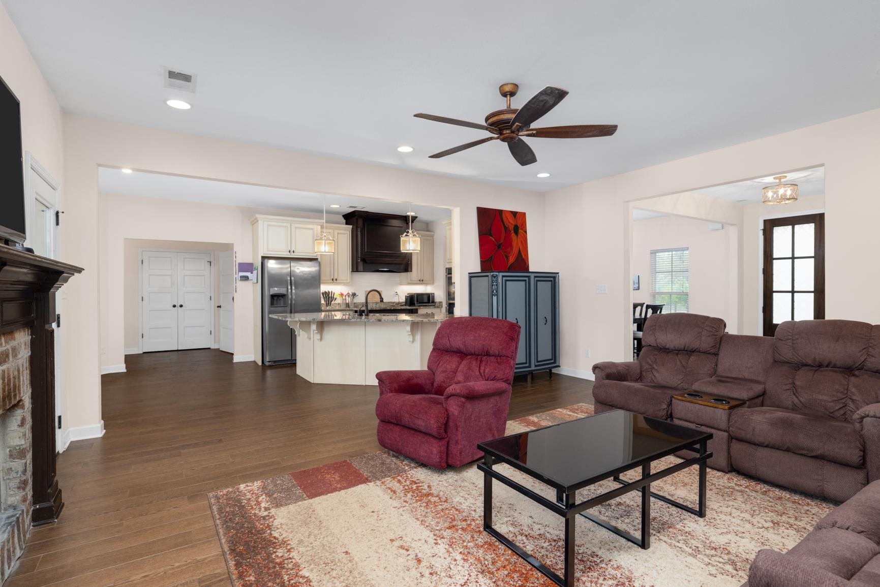 504 Bankston Road Nesbit, MS 38651 - Photo 10 of 39 Spacious living area featuring wood-finish flooring, a brick fireplace with a dark wood mantel, and a ceiling fan with integrated lighting