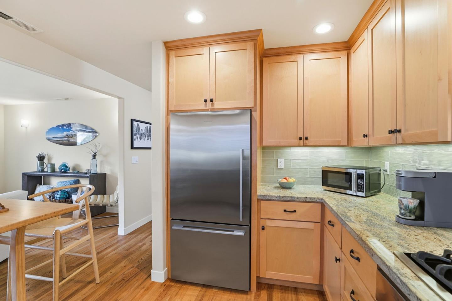 4570 Jewel Street Capitola, CA 95010 - Photo 13 of 45 a kitchen with kitchen island granite countertop a refrigerator a sink a stove and white cabinets with wooden floor