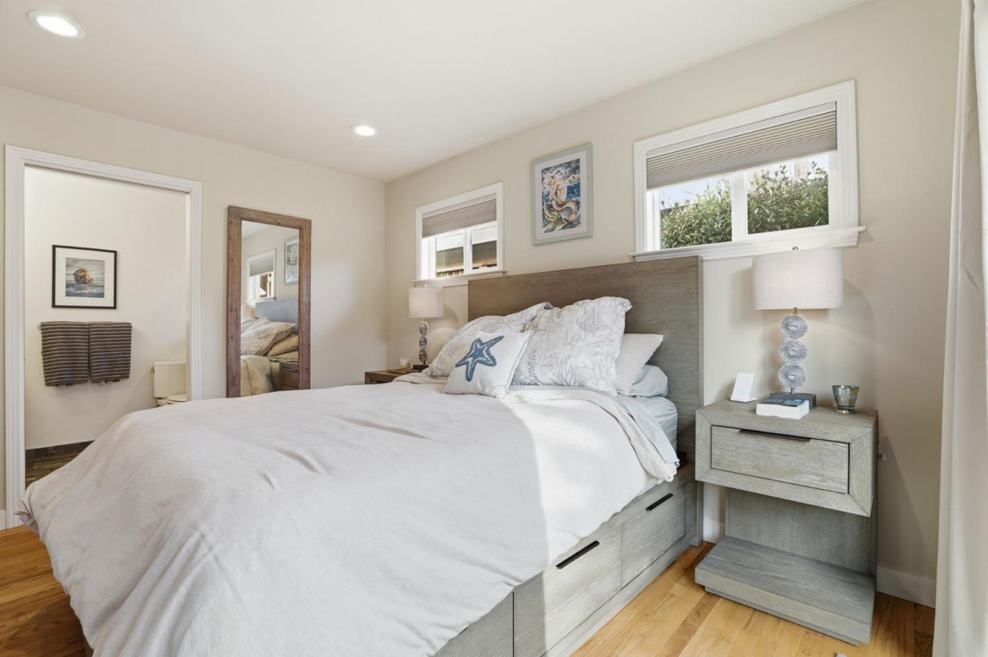 4570 Jewel Street Capitola, CA 95010 - Photo 16 of 45 a spacious bedroom with a bed and a large mirror