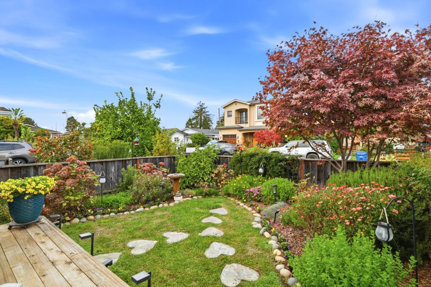 4570 Jewel Street Capitola, CA 95010 - Photo 6 of 45 a view of a garden with plants and a bench under palm trees
