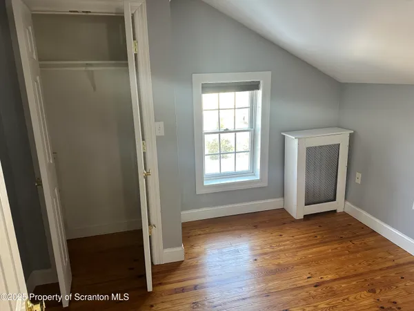 a view of empty room with wooden floor