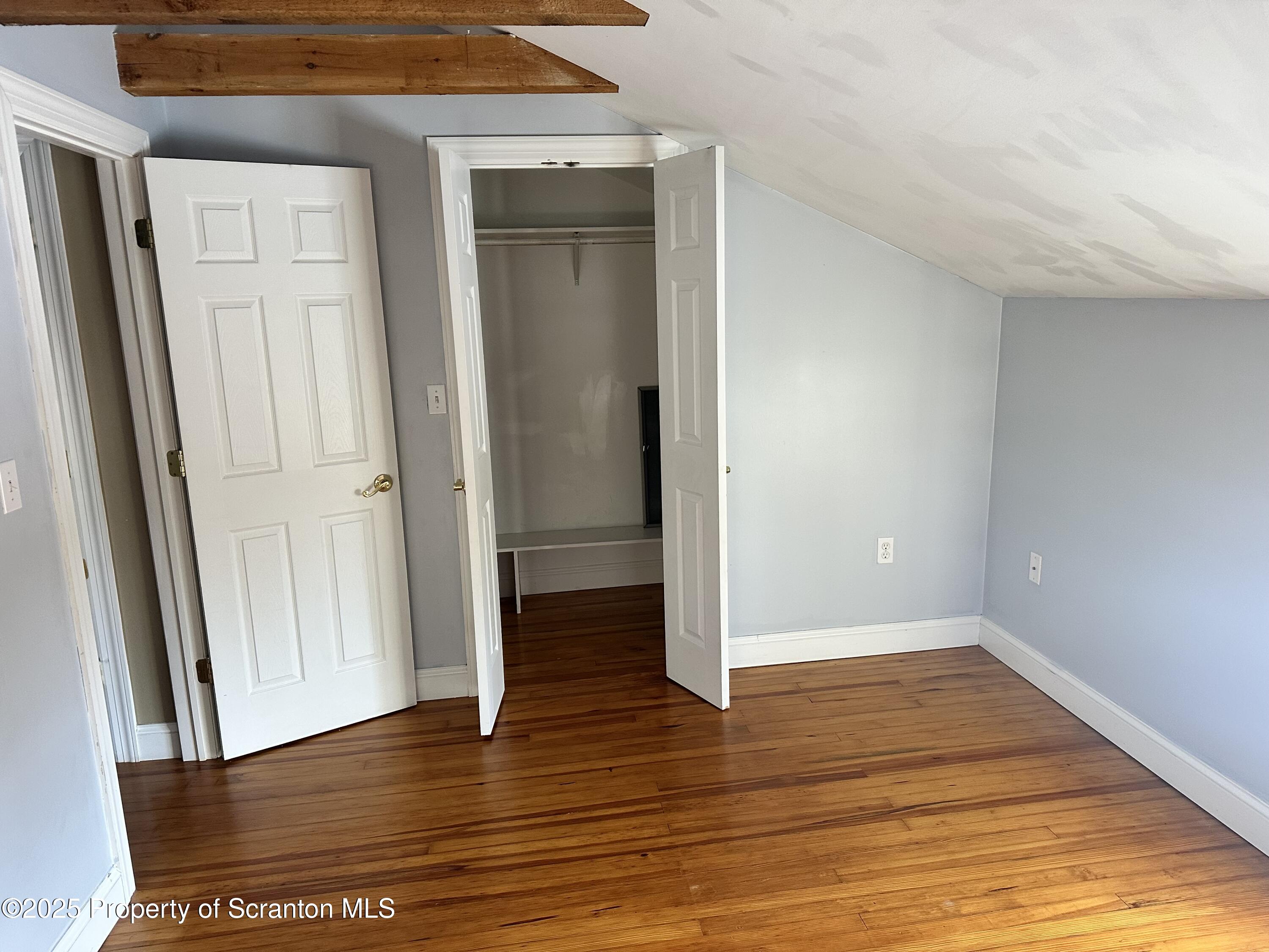 1108 North Abington Road Waverly, PA 18471 - Photo 14 of 32 an empty room with wooden floor and entrance