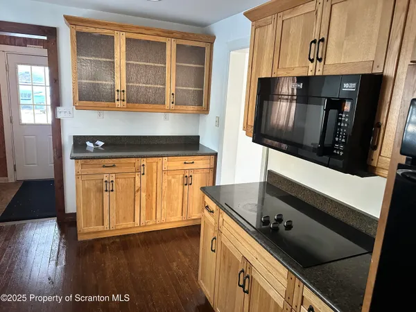 a kitchen with granite countertop a sink window and cabinets