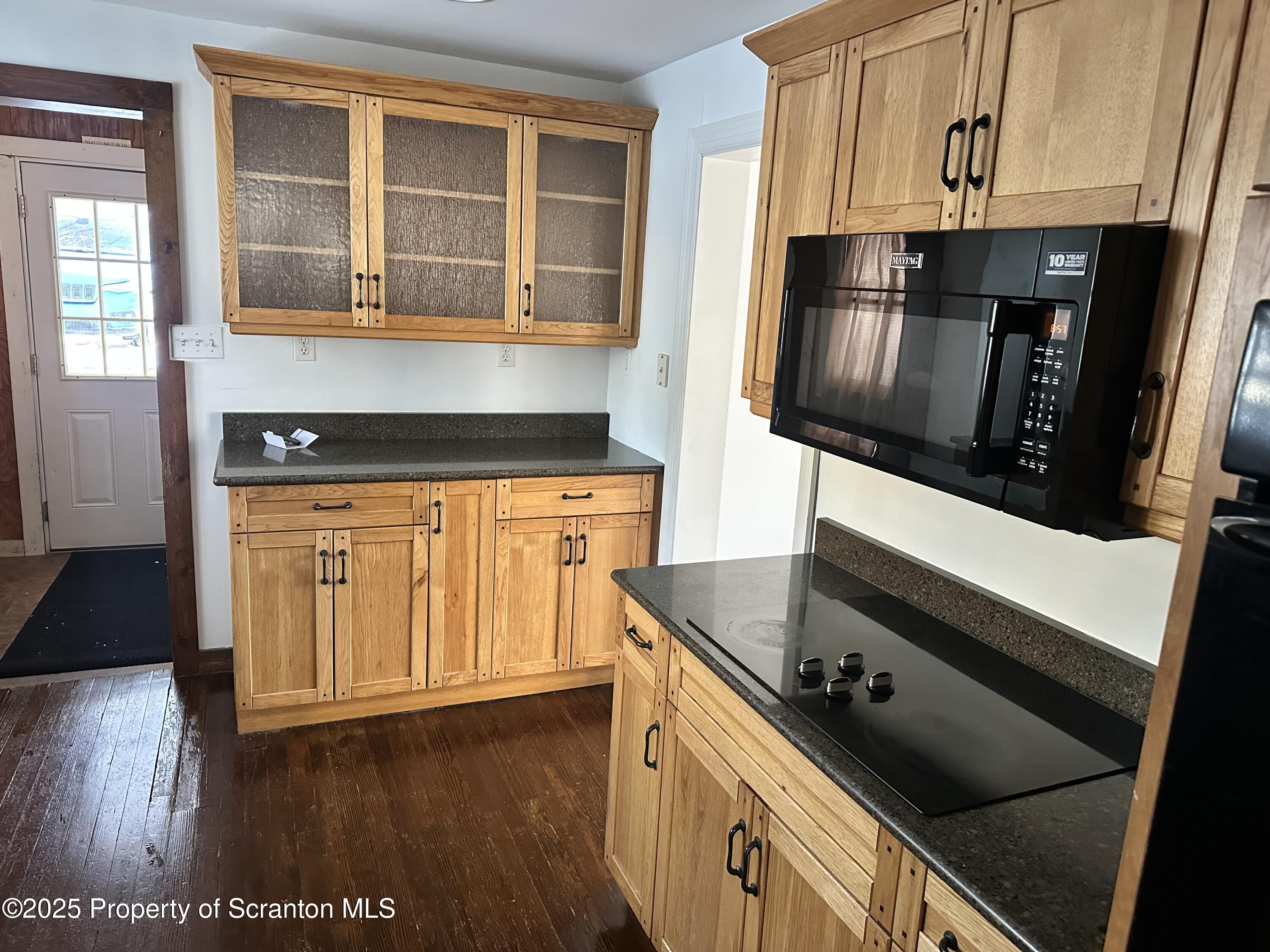 1108 North Abington Road Waverly, PA 18471 - Photo 24 of 32 a kitchen with granite countertop a stove and a wooden floor