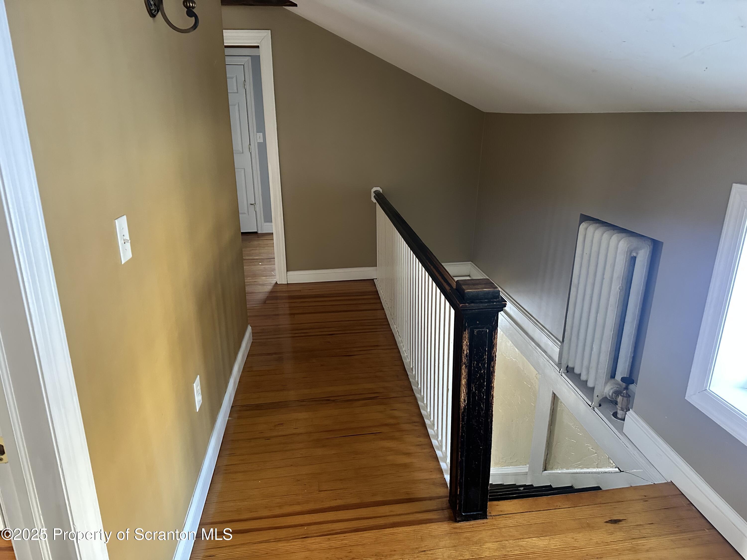 1108 North Abington Road Waverly, PA 18471 - Photo 7 of 32 a view of a hallway with wooden floor and staircase