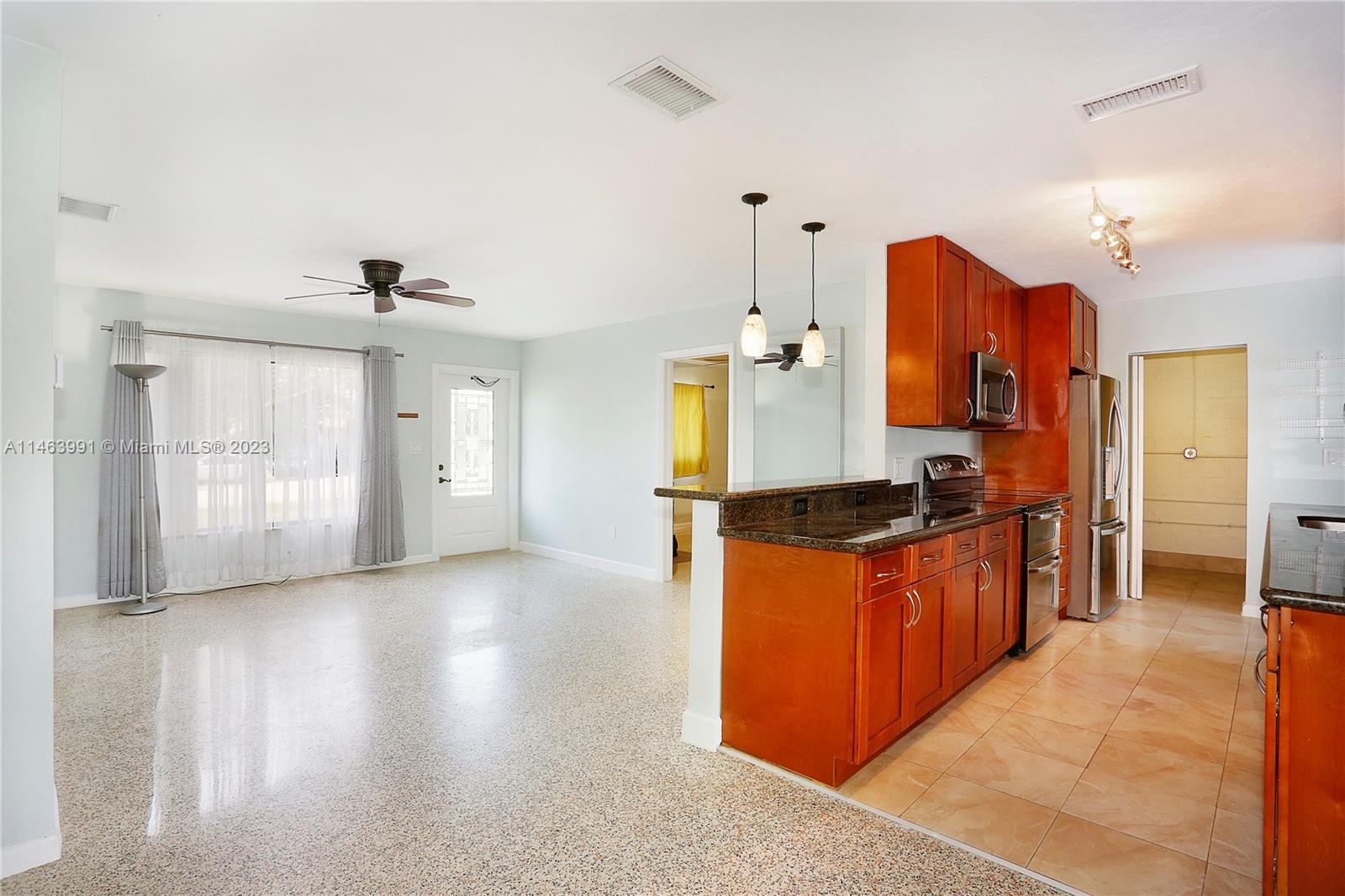 10045 Southwest 82nd Street Miami, FL 33173 - Photo 13 of 31 a large kitchen with stainless steel appliances granite countertop a stove a sink dishwasher and a refrigerator with wooden floor