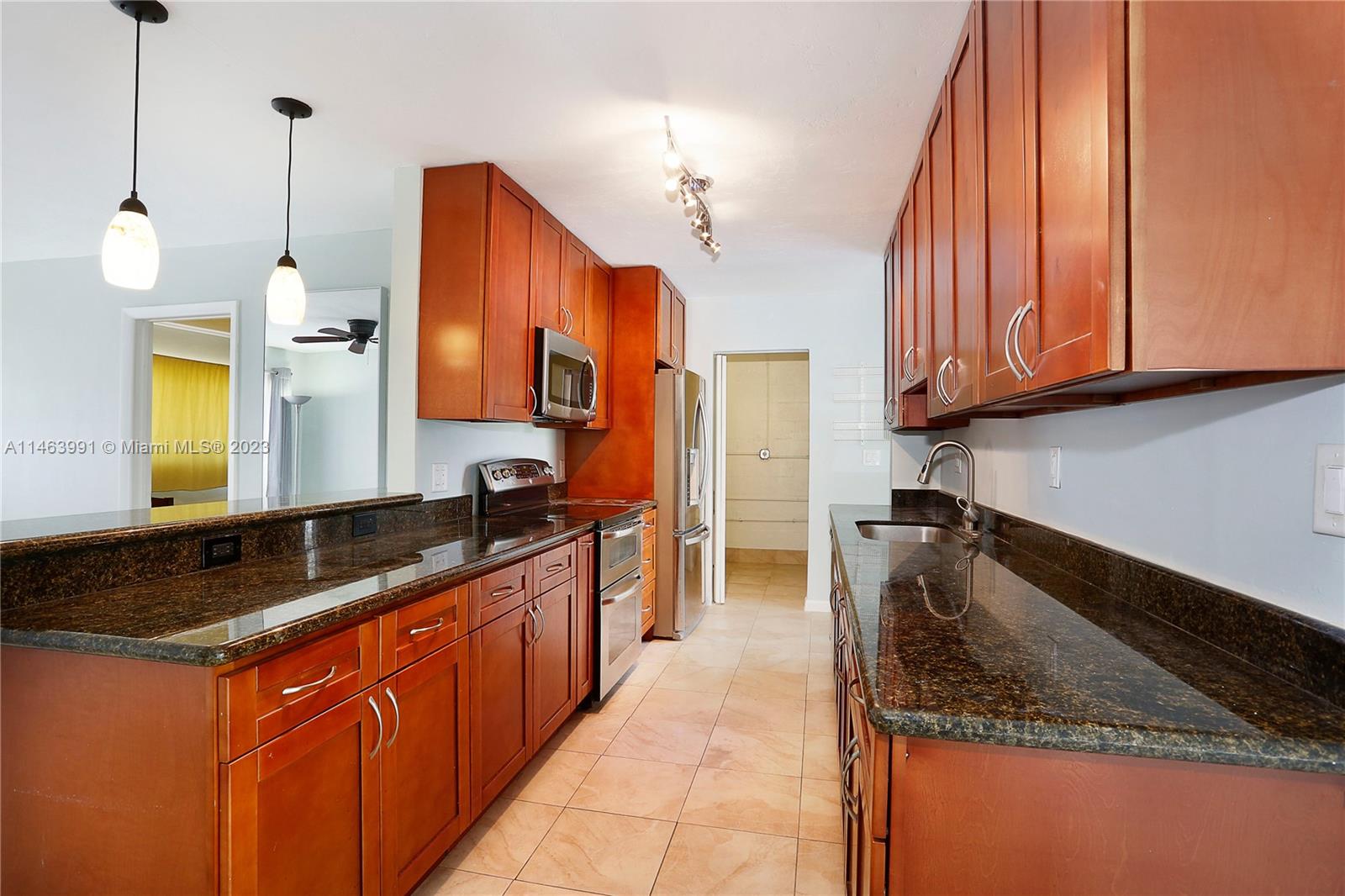 10045 Southwest 82nd Street Miami, FL 33173 - Photo 16 of 31 a kitchen with stainless steel appliances granite countertop a sink a stove and a wooden cabinets