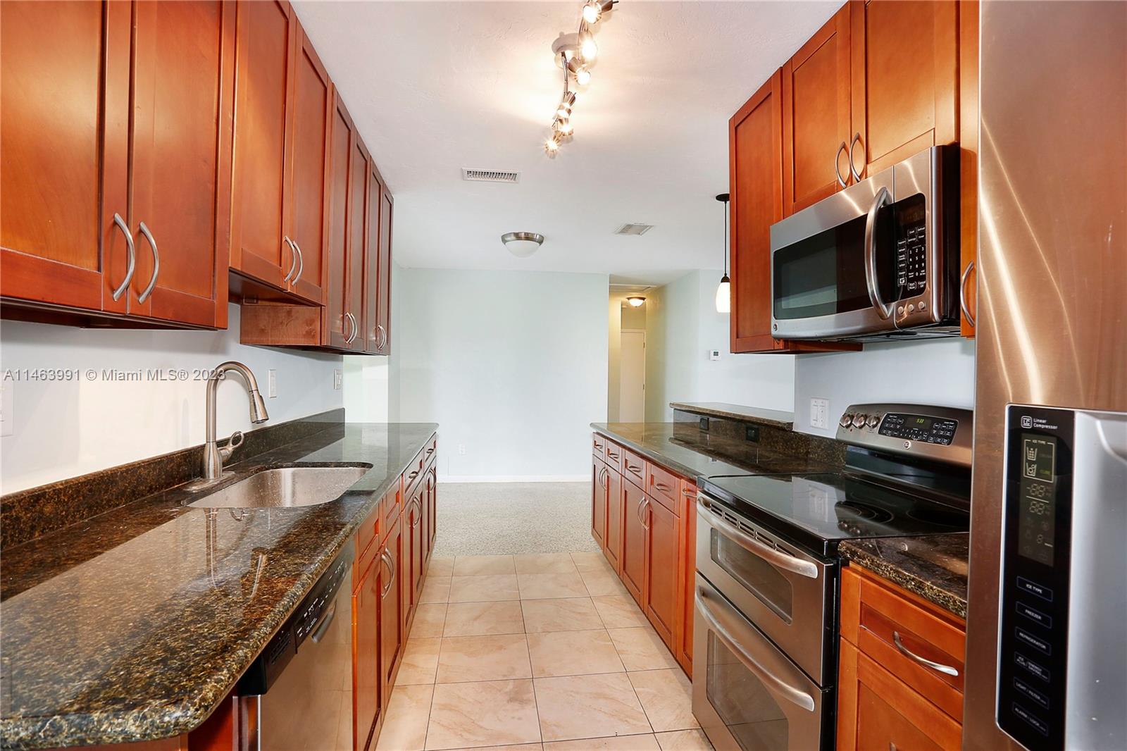 10045 Southwest 82nd Street Miami, FL 33173 - Photo 17 of 31 a kitchen with granite countertop wooden cabinets and a stove top oven