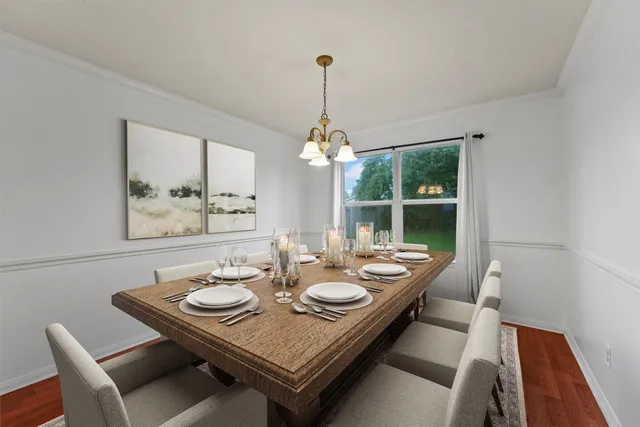 a dining room with wooden floor a chandelier a wooden table and chairs