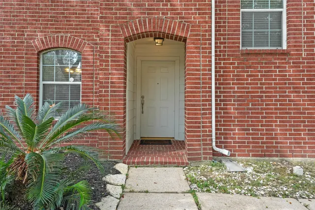 a view of a brick wall and potted plants