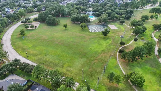 an aerial view of residential houses with outdoor space and trees all around