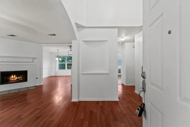 a view of a livingroom with wooden floor and a fireplace