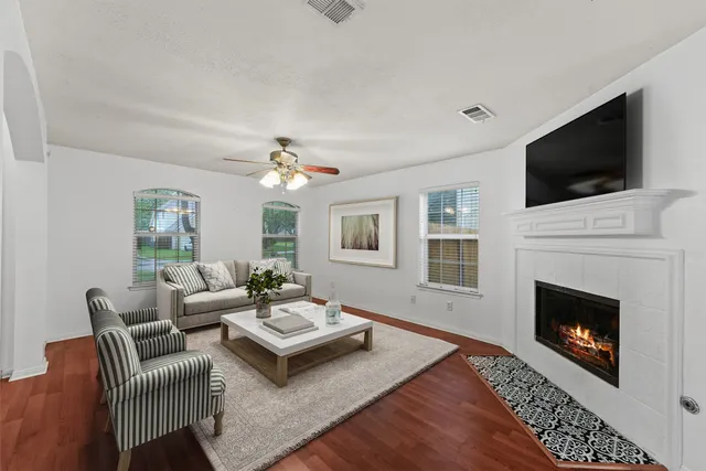 a living room with furniture a flat screen tv and a fireplace