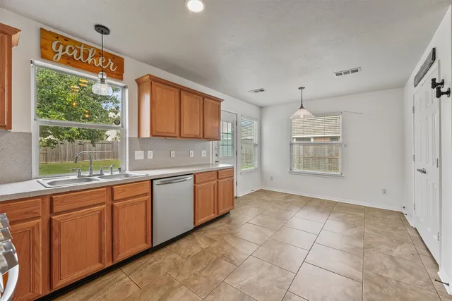 a large kitchen with granite countertop a stove a sink and a window